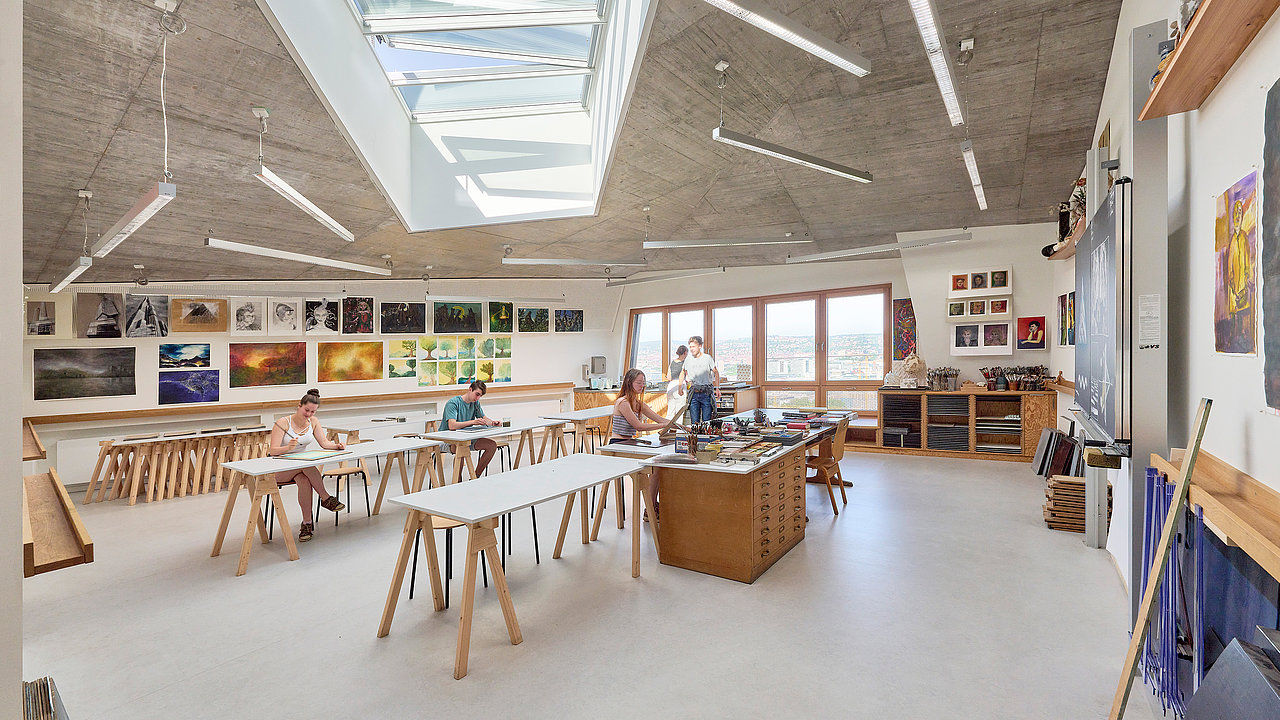 Blick in den Kunstraum der Schule. Einige Schüler sitzen verteilt an den Tischen und zeichnen etwas